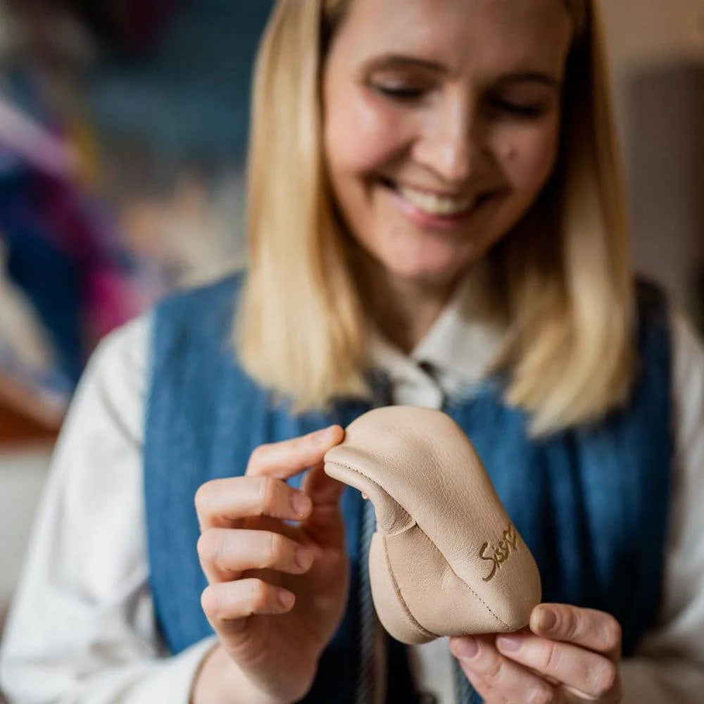Lieblinge Barfußschuhe Sissi  Rasche Krabbelschuh natur Sissi freut sich mit Schuh in der Hand