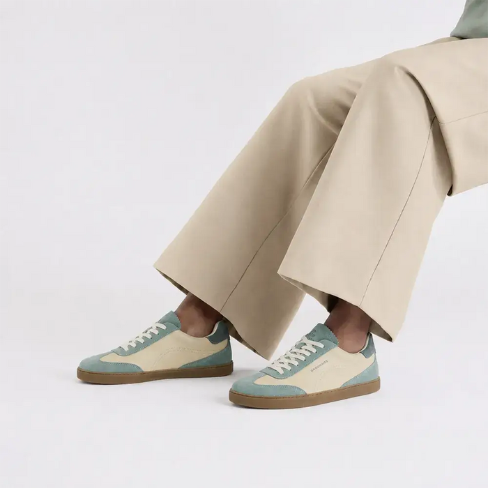 Lieblinge Barfußschuhe für Erwachsene. Groundies Barfuß Sneaker rin der Farbe sage - beige. Wunderschöne Silhouette zeitgeistiges Design mit tollem style. Model sitzt mit einer tollen, schlichten beigefarbenen Hose. Handmade in Portugal.
