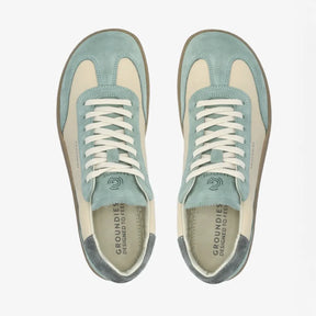 Lieblinge Barfußschuhe für Erwachsene. Groundies Barfuß Sneaker rin der Farbe sage - beige. Wunderschöne Silhouette zeitgeistiges Design mit tollem style. Model sitzt mit einer tollen, schlichten beigefarbenen Hose. Handmade in Portugal.
