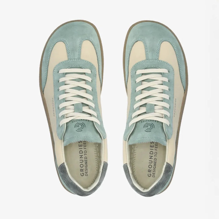 Lieblinge Barfußschuhe für Erwachsene. Groundies Barfuß Sneaker rin der Farbe sage - beige. Wunderschöne Silhouette zeitgeistiges Design mit tollem style. Model sitzt mit einer tollen, schlichten beigefarbenen Hose. Handmade in Portugal.
